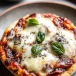 Individual golden-brown pizza pot pies being inverted onto white plates with melted cheese and pepperoni visible.