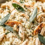 A creamy bowl of Parmesan cauliflower risotto topped with fresh parsley and extra cheese.