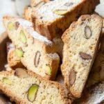 Golden brown keto almond biscotti slices with toasted almonds on a cooling rack