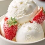 A bowl of creamy vanilla frozen yogurt topped with fresh berries