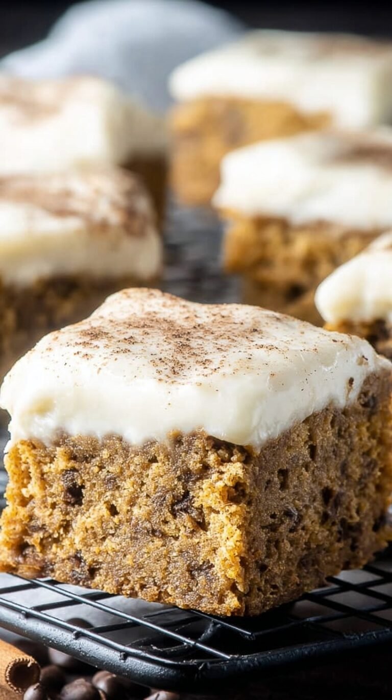 A stack of moist pumpkin bars with dark chocolate chips on a wooden board