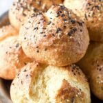 Golden brown keto dinner rolls with a glossy egg wash finish on a baking sheet