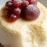 A creamy keto mug cheesecake topped with fresh berries in a white ceramic mug.