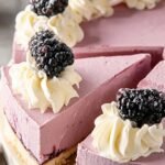 A slice of Keto Blackberry Cheesecake with a purple berry swirl on a white plate.