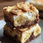 Golden banana pudding brownies topped with vanilla wafer cookies in a square baking pan