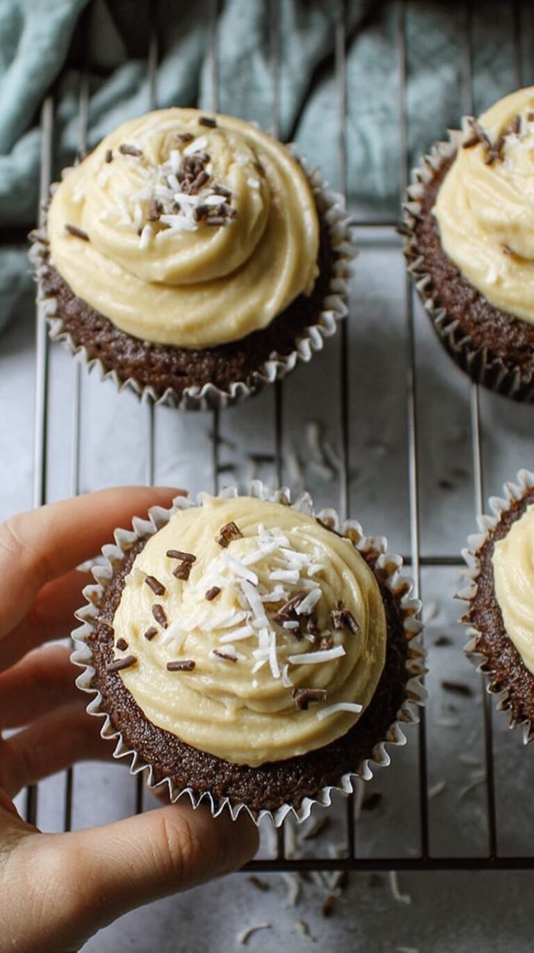 Six chocolate cupcakes with creamy white frosting on a wire cooling rack