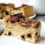 A slice of protein coffee cake with cinnamon streusel on a white plate.
