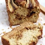 A golden loaf of Healthy Protein Banana Bread with a peanut butter swirl and dark chocolate chips on top.