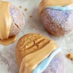 Six chocolate-covered protein peanut butter eggs on parchment paper