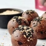 Dark chocolate tahini protein balls on a parchment-lined sheet