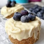 Six mini protein cheesecakes in silicone liners with a dark protein bar crust and creamy vanilla filling.