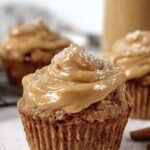 A plate of protein apple cupcakes topped with smooth peanut butter frosting and fresh apple slices.