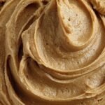 A bowl of thick and creamy peanut butter frosting made with protein powder and greek yogurt.