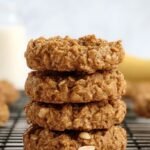 A tray of golden-brown banana cereal cookies with dark chocolate chips on a wire rack.