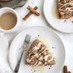Six golden-brown gluten-free apple cinnamon scones on a parchment-lined baking sheet