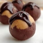 A tray of dark chocolate coated peanut butter protein truffles topped with sea salt
