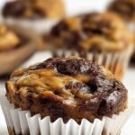 A close up of marbled chocolate and peanut butter banana muffins on a wire rack