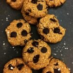 A tray of golden brown chickpea chocolate chip cookies with melted dark chocolate