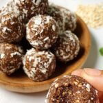 A tray of smooth chocolate protein balls lined with parchment paper.