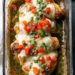 A baking dish showing chicken breasts topped with fresh pico de gallo and melted Monterey Jack cheese.