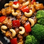 A skillet of Easy Cashew Chicken with bell peppers and roasted cashews served over white rice.