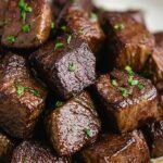 Slow cooker filled with tender beef steak bites garnished with fresh parsley