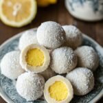 A plate of white chocolate lemon truffles coated in powdered sugar