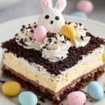 A tiered chocolate lasagna dessert topped with pastel candy eggs and sprinkles in a glass dish.