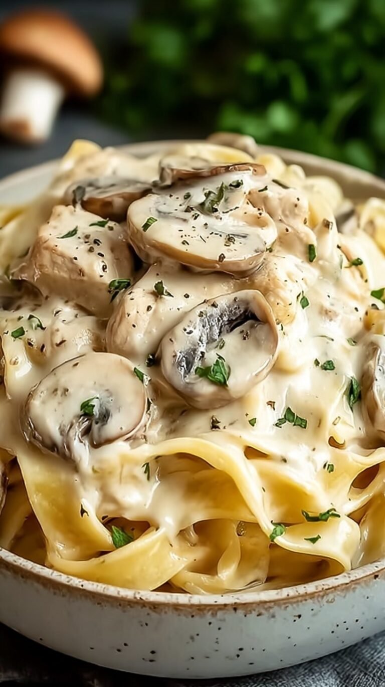 A white bowl filled with creamy chicken and mushroom tagliatelle topped with fresh parsley