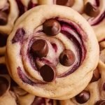 Close up of several soft cherry chocolate chip cookies on a wire cooling rack with melted mocha chips and chopped dried cherries.