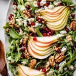 A fresh winter salad with sliced pears, toasted walnuts, and crumbled Gorgonzola on a bed of mixed greens.