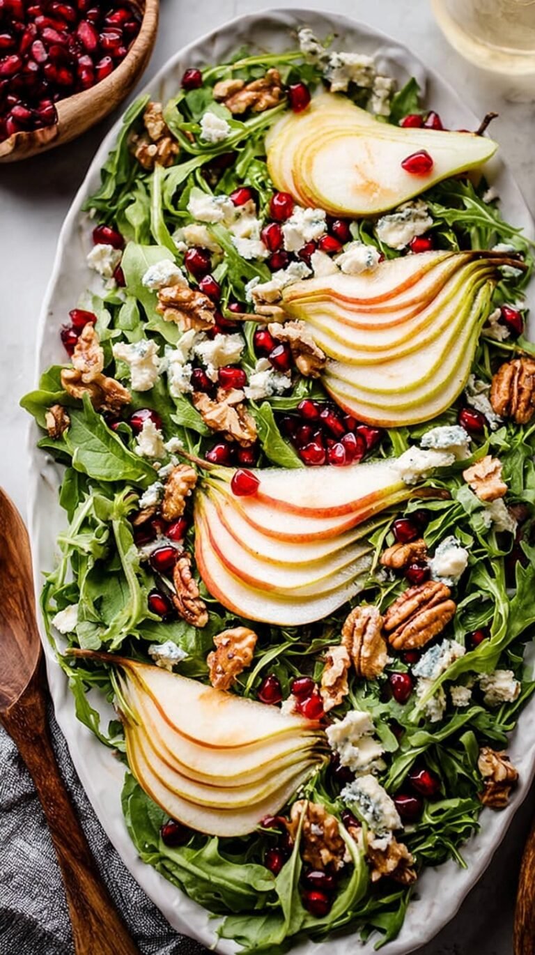 A fresh winter salad with sliced pears, toasted walnuts, and crumbled Gorgonzola on a bed of mixed greens.