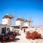 A beautiful view of white buildings and blue water in Mykonos Greece