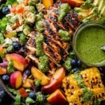 A large platter of Summer Chicken Cobb Salad with rows of grilled chicken, peaches, charred corn, avocado, and eggs.