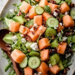 A bright bowl of cucumber melon salad with fresh mint and crumbled feta cheese.