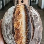 A perfectly cooked salmon fillet with bright orange carrots and a creamy green herb sauce on a white plate.