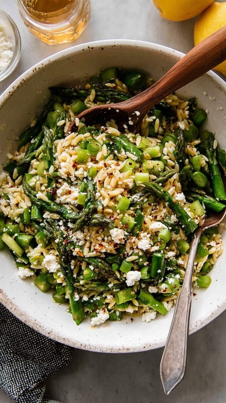 A bright bowl of asparagus orzo salad with feta cheese and pine nuts