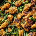 Pan-seared chicken pieces coated in a golden turmeric and hot honey glaze with sliced scallions.