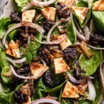 A fresh baby spinach salad with sliced Medjool dates and golden pita chips