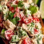 A vibrant cilantro lime chicken salad with grilled chicken, black beans, corn, and avocado in a large bowl.