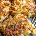 A baking sheet filled with golden brown, crispy shredded hash browns.