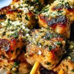 Grilled Garlic Parmesan Chicken Skewers on a white platter garnished with fresh parsley