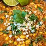 A bowl of creamy white chicken chili topped with cotija cheese, cilantro, and tajin seasoning.