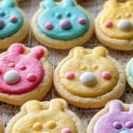 Shortbread bunny button cookies with pink ears and button holes on a white plate