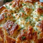 A golden brown pull-apart bread loaf stuffed with melted mozzarella and garlic herbs