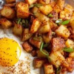 Golden brown diced air fryer home fries in a bowl with herbs