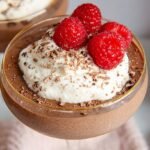 A smooth and creamy chocolate mousse served in glass ramekins topped with dark chocolate shavings.