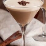 A creamy Baileys Espresso Martini in a chilled glass with three coffee beans on top.