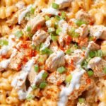 A bowl of creamy buffalo chicken mac and cheese garnished with fresh chives.