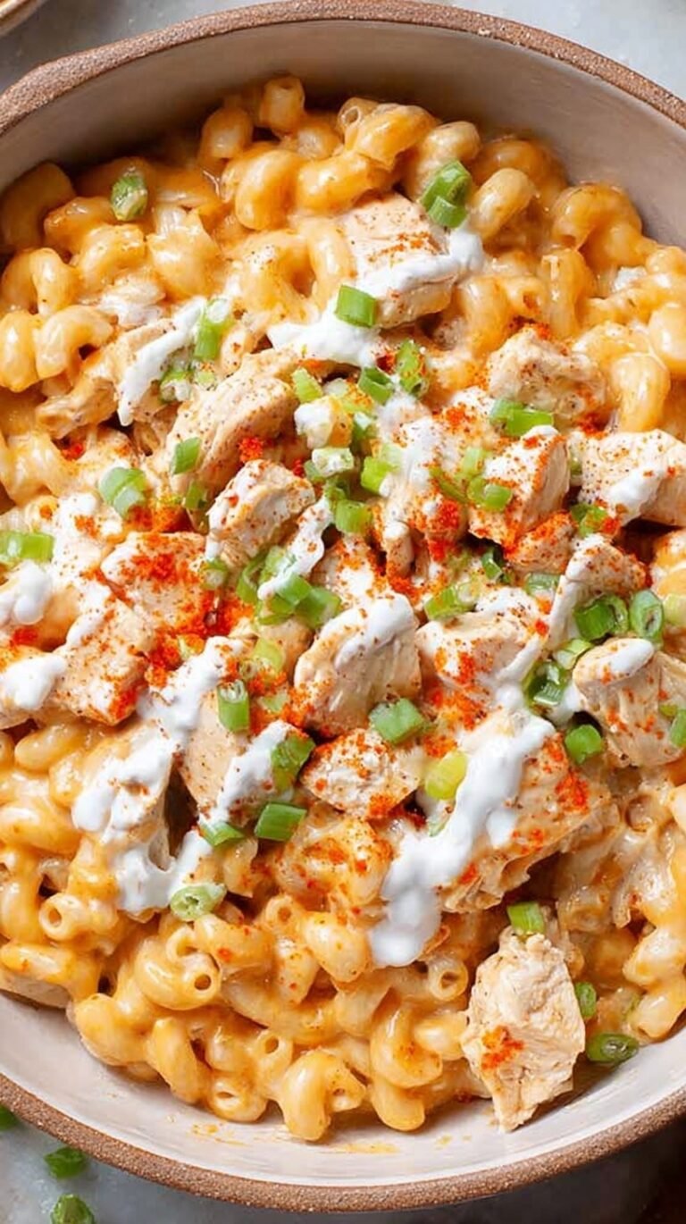 A bowl of creamy buffalo chicken mac and cheese garnished with fresh chives.